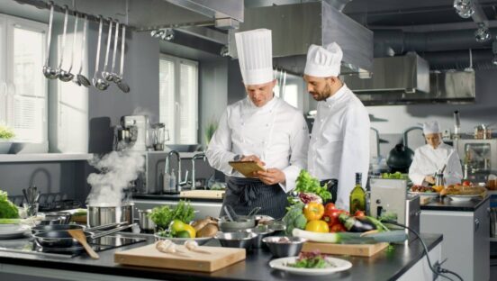 Chefs Work on a Big Restaurant Stainless Steel Professional Kitchen.