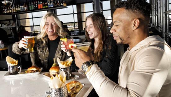 Bar Louie guests with drinks at the bar.