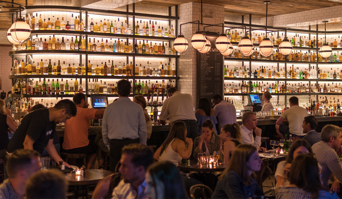 Inside A Crowded Restaurant With A Bar In The Background