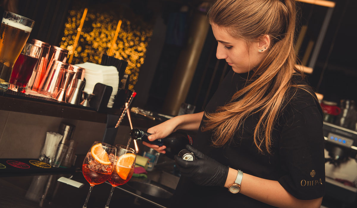 A Bartender Pours Cocktails Into Glasses