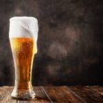 Beer frothing out of a glass.