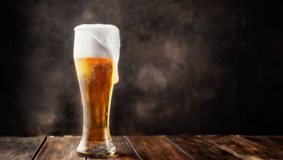 Beer frothing out of a glass.