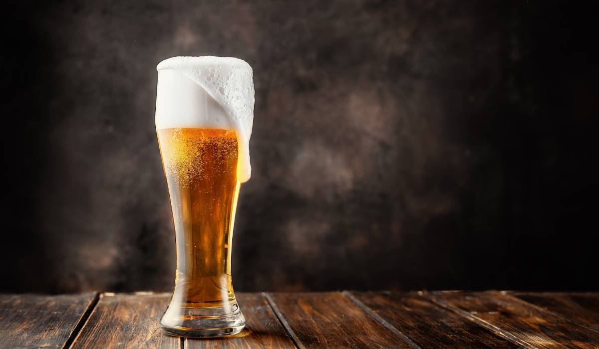 Beer frothing out of a glass.