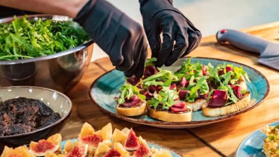 Catering plate being prepared by a chef with gloves.