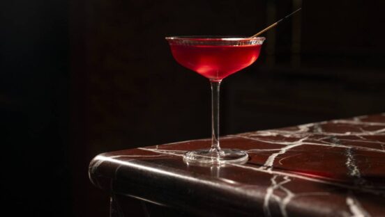 Cocktail at Crane Club, red drink against black background.