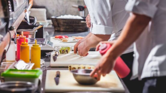 Chefs making food in a kitchen.