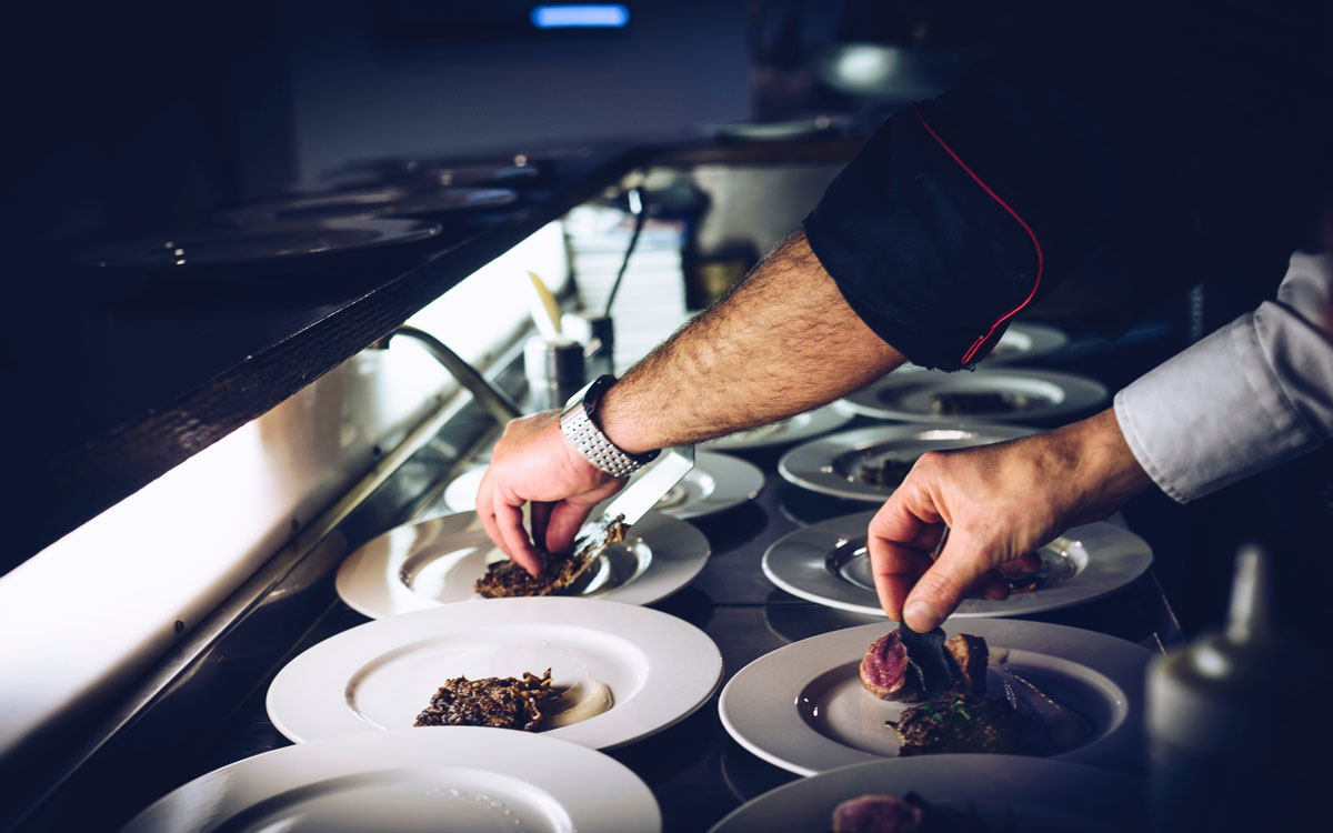 Two Chefs Plate Food In A Commercial Restaurant Kitchen