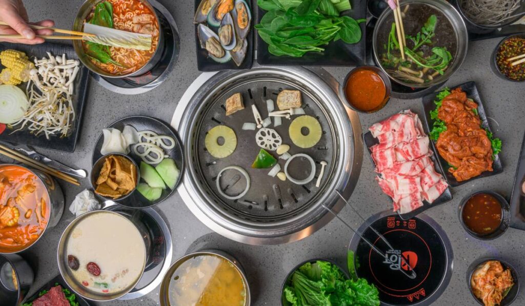 At KPOT, guests use tablets to order a variety of meats, vegetables, and soups, with ingredients cooked hot pot or Korean barbecue style at the table.