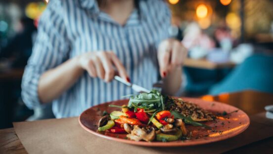 Close up of person eating in restaurant.