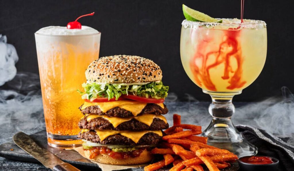 This beast of a burger comes stacked with three juicy beef patties, six slices of melty cheese, pickle relish, onion, pickles, lettuce, tomato and mayo, served on a black-and-white sesame seed bun