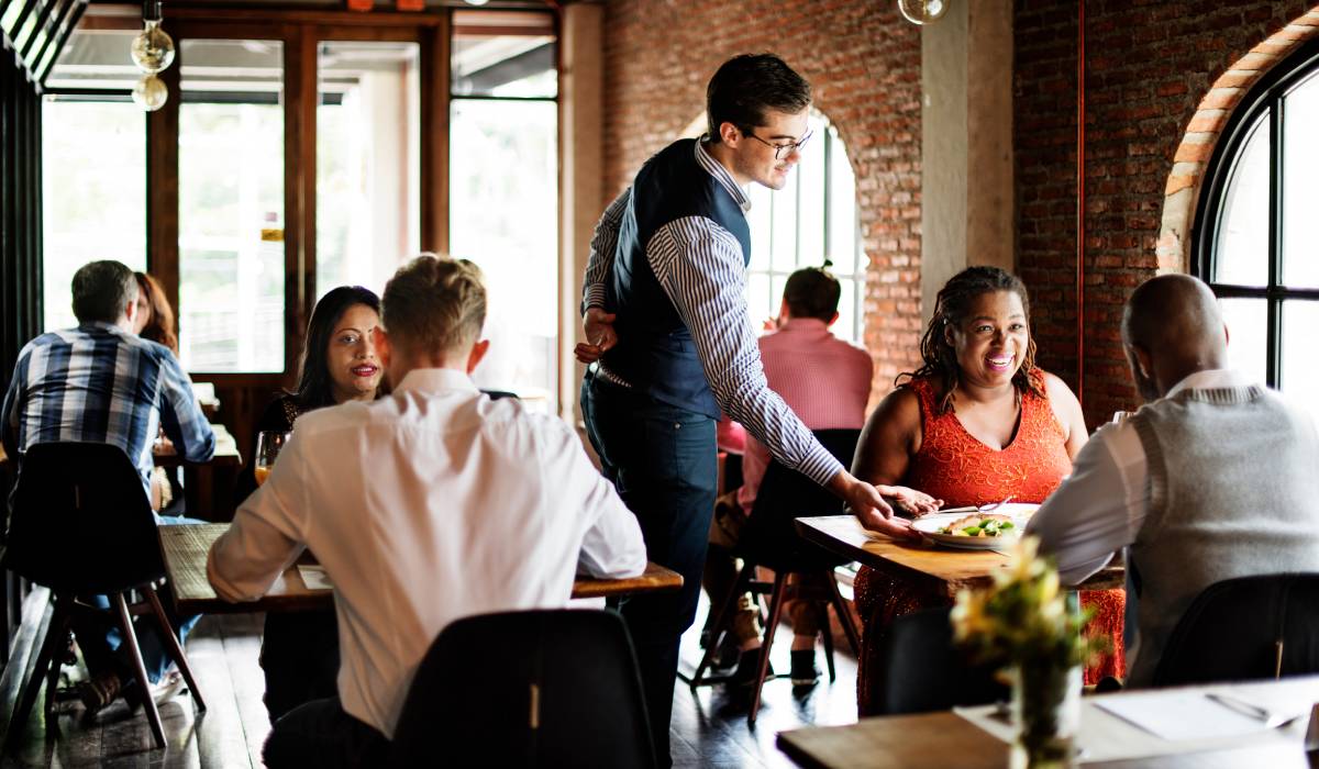 Restaurant Waiter Serves A Table Of Customers