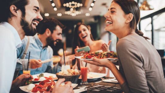 Restaurant customers smiling while having a meal.