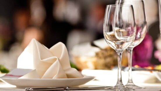 Table set with wine glasses at full-service restaurant.