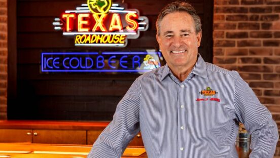 Texas Roadhouse CEO Jerry Morgan by a Texas Roadhouse sign.